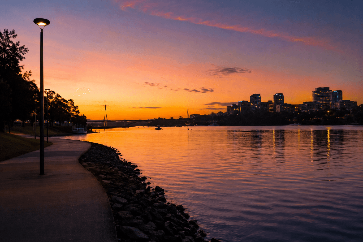 Parramatta River foreshore at dusk, with the city lights reflecting on the water